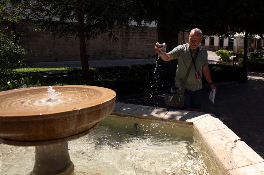 Un hombre sumerge su sombrero en una fuente para refrescarse en Ronda, en el sur de España, durante la primera ola de calor del verano, el 2 de julio de 2025. (Jorge Guerrero/AFP vía Getty Images)