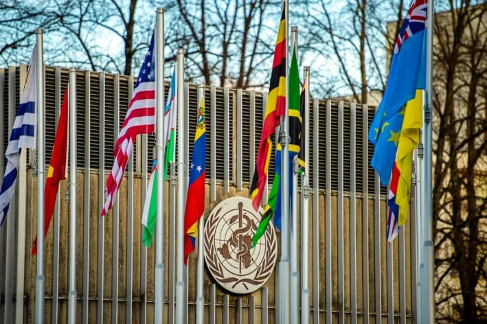 El logotipo de la OMS y la bandera de Estados Unidos frente a la sede de la Organización Mundial de la Salud en Ginebra, el 23 de enero de 2025. La administración Trump citó la gestión de la OMS de la pandemia de COVID-19 y la financiación desproporcionada de Estados Unidos como razones para retirarse de la organización. (Robert Hradil/Getty Images)