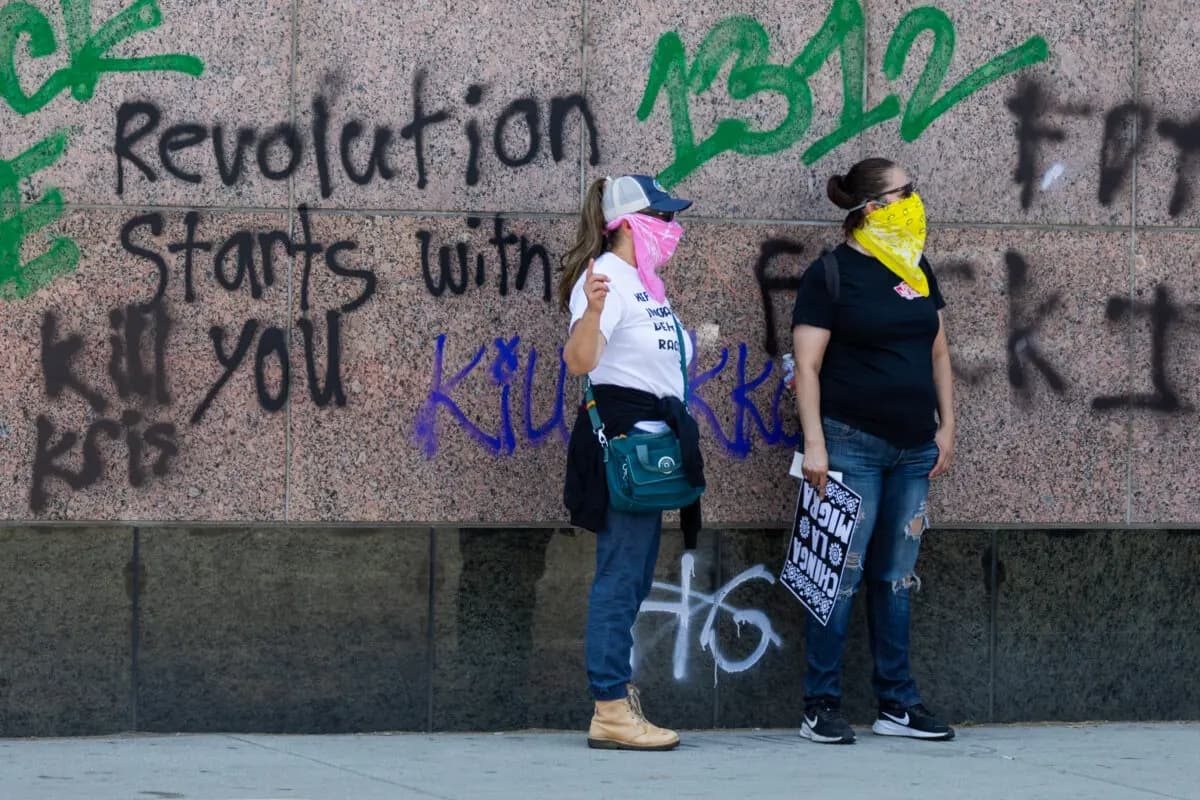 Manifestantes frente a pintadas contra el ICE en un edificio federal en Los Ángeles el 8 de junio de 2025. (John Fredricks/The Epoch Times)