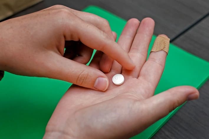 Una paciente se prepara para tomar la primera de dos píldoras combinadas, mifepristona, para un aborto con medicamentos durante una visita a una clínica en Kansas City, Kansas, el 12 de octubre de 2022. (Charlie Riedel/AP Photo)
