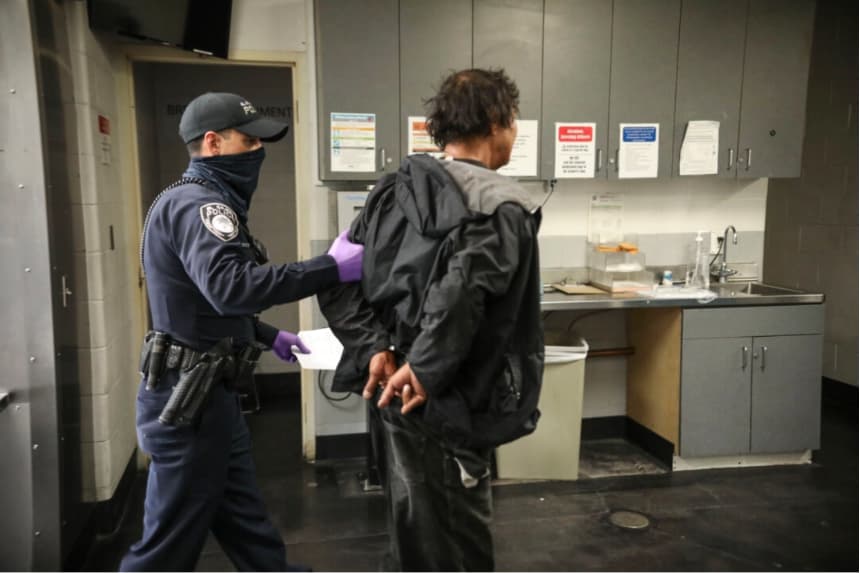 Un oficial de policía de El Cajón ingresa a un hombre en la cárcel del condado de San Diego el 24 de abril de 2020, en San Diego, California. Sandy Huffaker/Getty Images