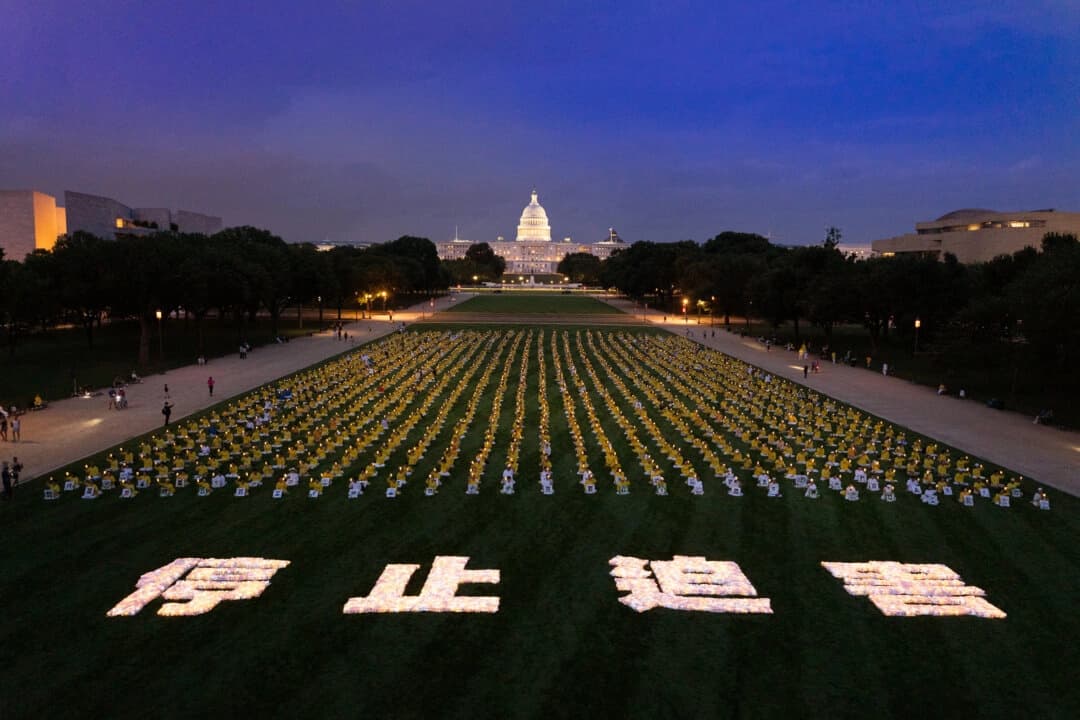 Practicantes de Falun Dafa participan en una vigilia con velas en memoria de los practicantes de Falun Gong que fueron perseguidos hasta la muerte por el Partido Comunista Chino en China, en Washington, el 17 de julio de 2025. (Larry Dye/The Epoch Times)