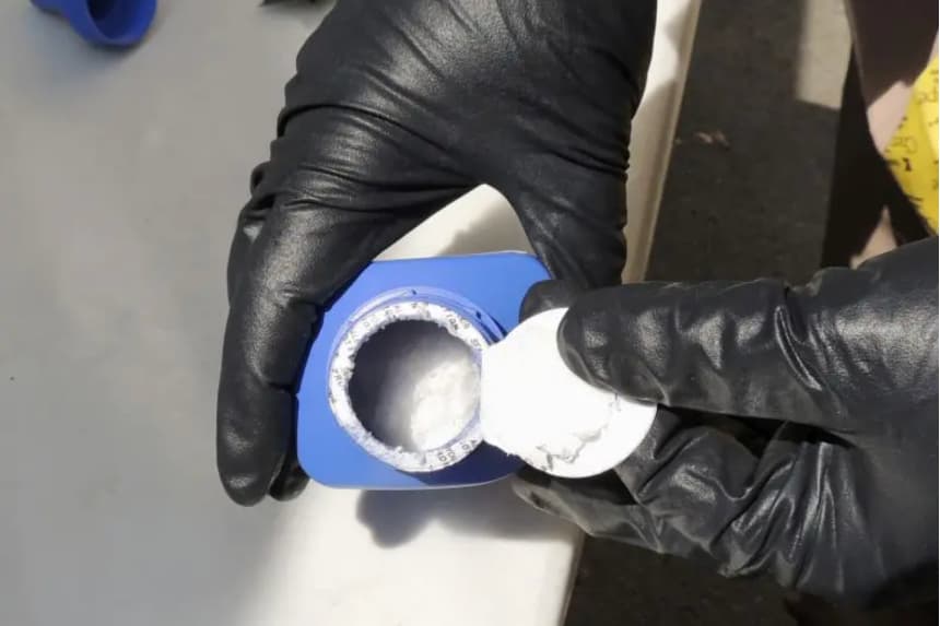 Un agente abre un bote de tinta para impresora que contiene carfentanilo, un opioide importado de China, en Vancouver, el 27 de junio de 2016. Los traficantes de drogas han estado mezclando carfentanilo y su primo más débil, el fentanilo, con heroína para aumentar sus márgenes de beneficio. Real Policía Montada de Canadá vía AP