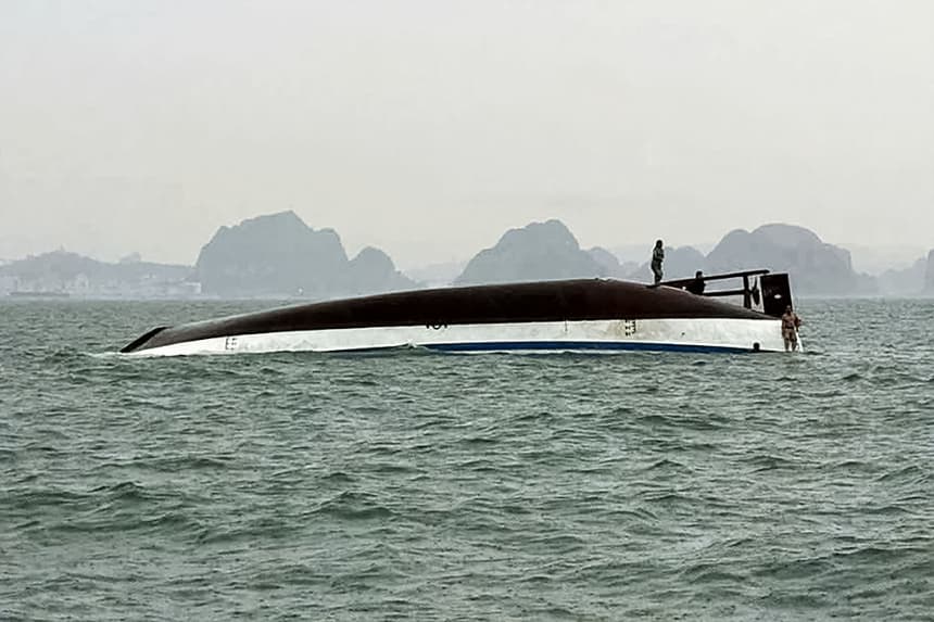Un hombre se encuentra en un barco turístico que volcó en la bahía de Ha Long, provincia de Quang Ninh (Vietnam), el 19 de julio de 2025. (AFP vía Getty Images)