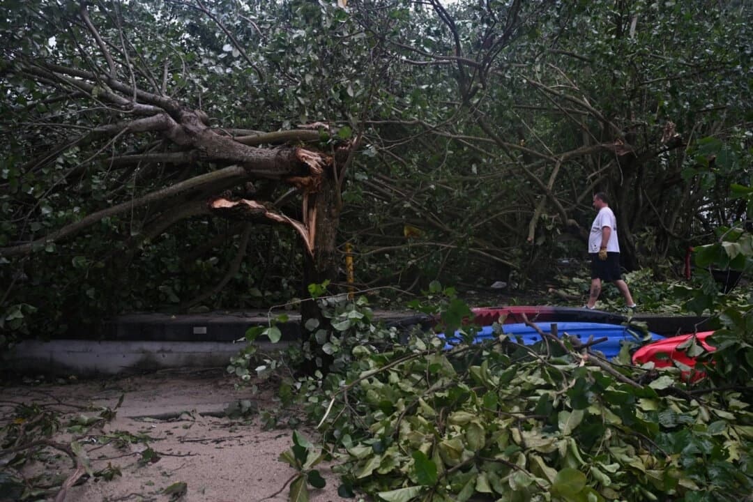 Un residente local intenta retirar un árbol caído de un camino de playa en la isla de Lantau, en Hong Kong, el 21 de julio de 2025. Hong Kong volvió a la normalidad al día siguiente de que el tifón Wipha pasara a 38 millas de la ciudad, lo que provocó la alerta máxima por ciclón tropical, T10, durante unas siete horas el 20 de julio de 2025. (Peter Parks/AFP a través de Getty Images)
