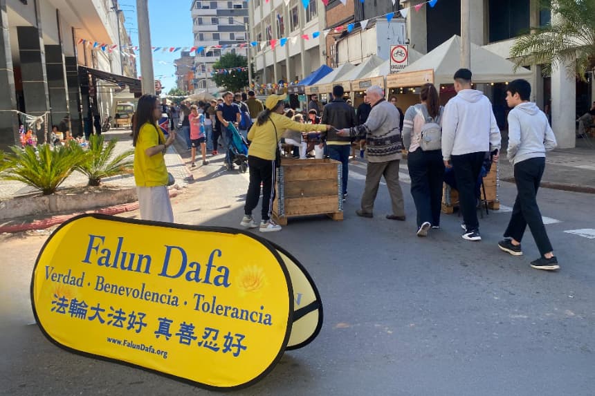 Practicantes de Falun Dafa informan sobre la persecución a la disciplina a manos del PCCh a los visitantes de la feria Palmear, en Asunción, Paraguay, el 20 de julio de 2025. (The Epoch Times)