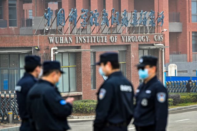 Personal de seguridad monta guardia frente al Instituto de Virología de Wuhan mientras miembros del equipo de la Organización Mundial de la Salud investigan los orígenes de COVID-19, en Wuhan, provincia de Hubei, China, el 3 de febrero de 2021. (Héctor Retamal/AFP vía Getty Images)
