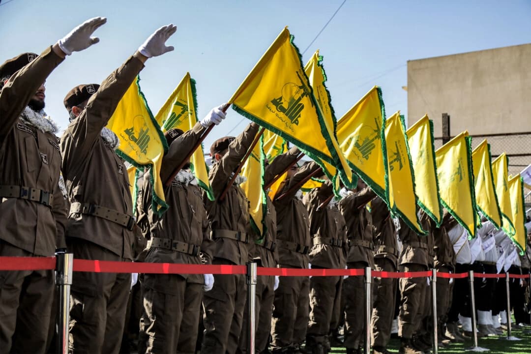 Miembros de Hezbolá saludan e izan las banderas del grupo durante el funeral de Ismail Baz y Mohamad Hussein Shohury, quienes murieron en un ataque israelí contra sus vehículos, en Shehabiya, Líbano, el 17 de abril de 2024. (AFP vía Getty Images)

