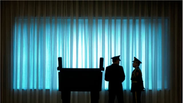 Oficiales del Ejército Popular de Liberación (EPL) de China se encuentran frente a una ventana antes de la ceremonia de bienvenida al Jefe del Estado Mayor del Ejército de EE. UU., general Mark Milley, en el Edificio Bayi de Beijing el 16 de agosto de 2016. Mark Schiefelbein/POOL/AFP vía Getty Images