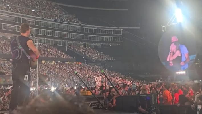 Chris Martin habla en el escenario sobre una pareja que aparece en la pantalla gigante durante un concierto de Coldplay en Foxborough, Massachusetts, el 16 de julio de 2025, en una imagen del vídeo. (@calebu2/TMX vía AP)