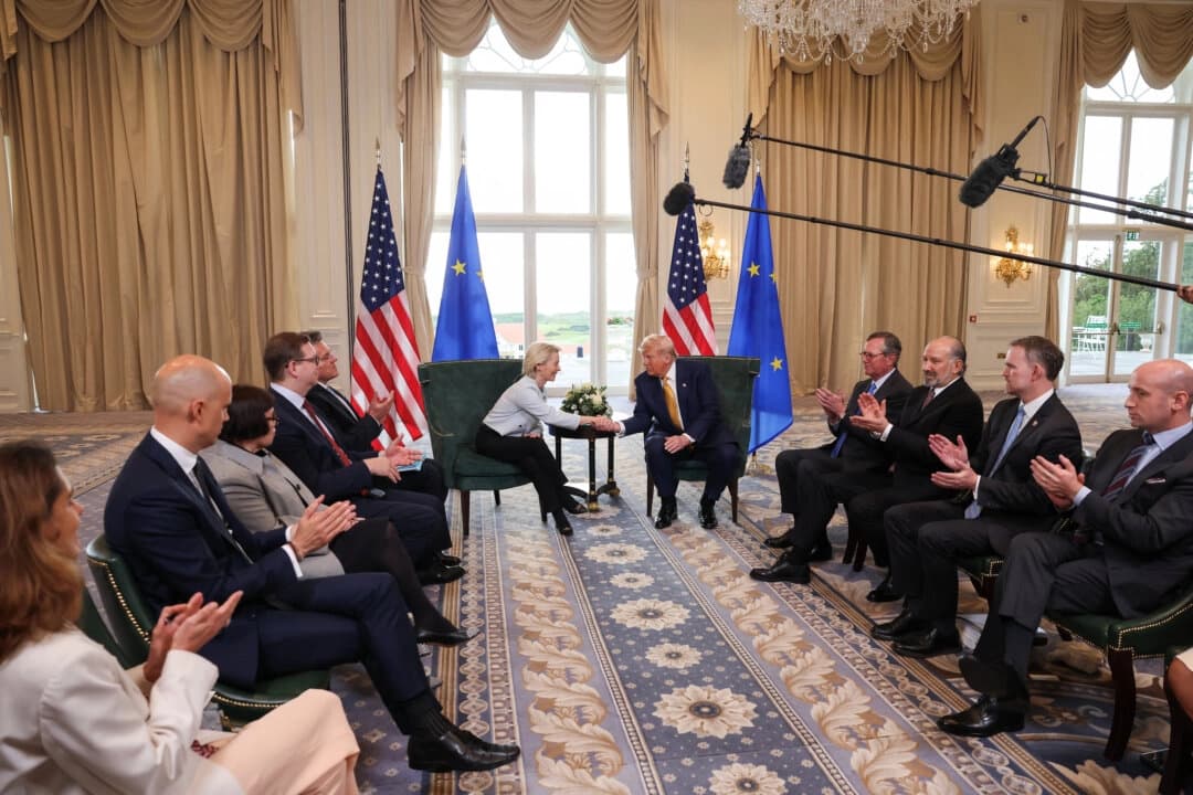 El presidente de Estados Unidos, Donald Trump, estrecha la mano de la presidenta de la Comisión Europea, Ursula von der Leyen, mientras el secretario de Comercio estadounidense, Howard Lutnick, el representante comercial, Jamieson Greer, y el subjefe de gabinete de la Casa Blanca, Stephen Miller, aplauden, en Turnberry, Escocia, Gran Bretaña, el 27 de julio de 2025. (Evelyn Hockstein/Reuters)