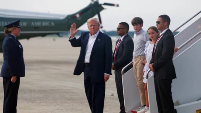El presidente de Estados Unidos, Donald Trump, acompañado por sus nietos Chloe Trump y Spencer Trump, saluda al bajar del Air Force One a su regreso de Escocia en la Base Conjunta Andrews, en Maryland, el 29 de julio de 2025. (Evelyn Hockstein/Reuters)