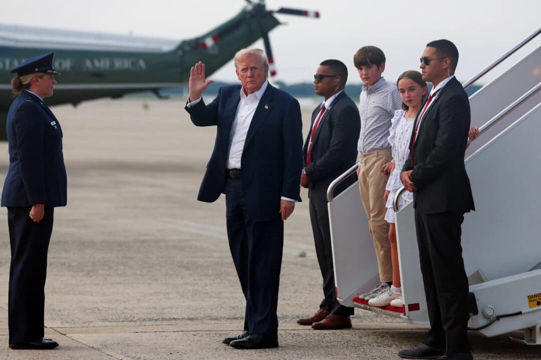 El presidente de Estados Unidos, Donald Trump, acompañado por sus nietos Chloe Trump y Spencer Trump, saluda al bajar del Air Force One a su regreso de Escocia en la Base Conjunta Andrews, en Maryland, el 29 de julio de 2025. (Evelyn Hockstein/Reuters)