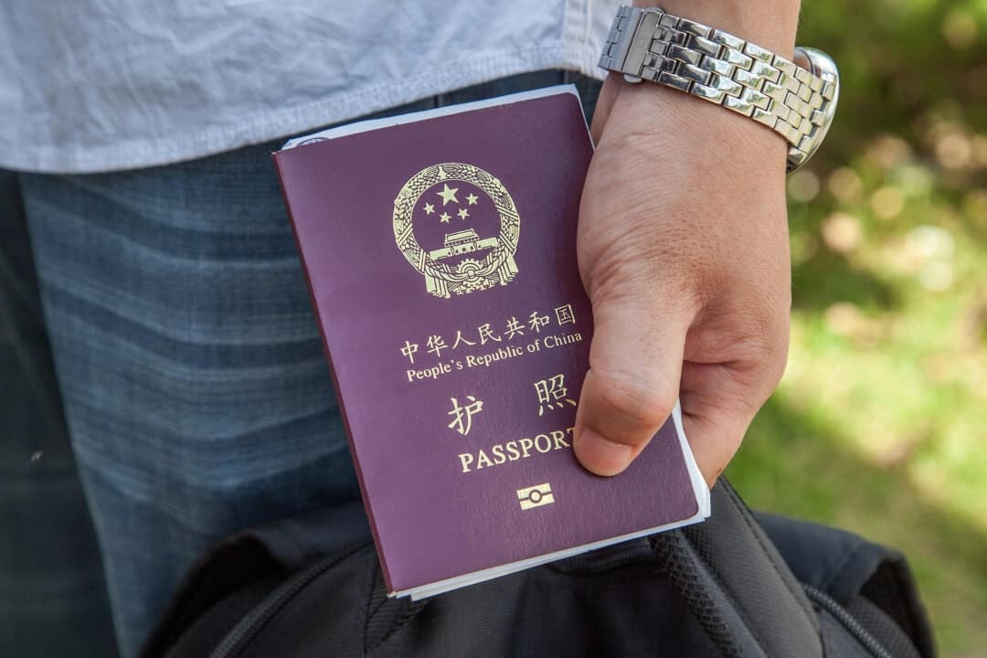 Un ciudadano chino sostiene un pasaporte chino en una fotografía de archivo. (Omar Havana/Getty Images).