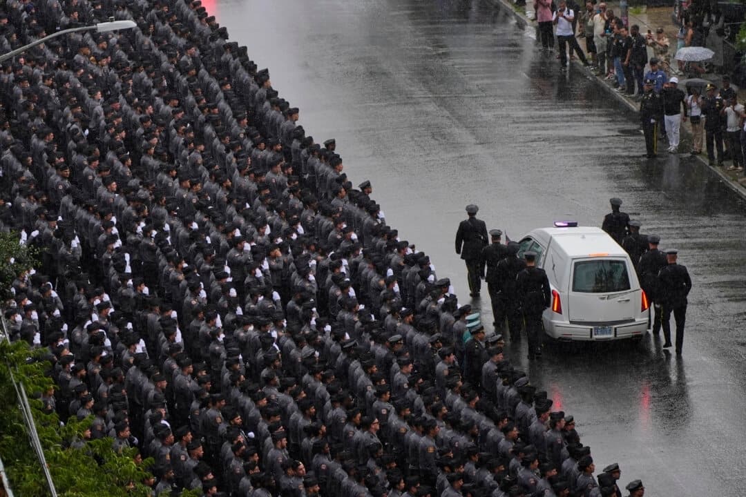 Oficiales de la policía de Nueva York saludan al pasar el coche fúnebre que transporta el féretro del oficial Didarul Islam, de la policía de Nueva York, tras su funeral en Nueva York el 31 de julio de 2025. (Yuki Iwamura/AP Photo)
