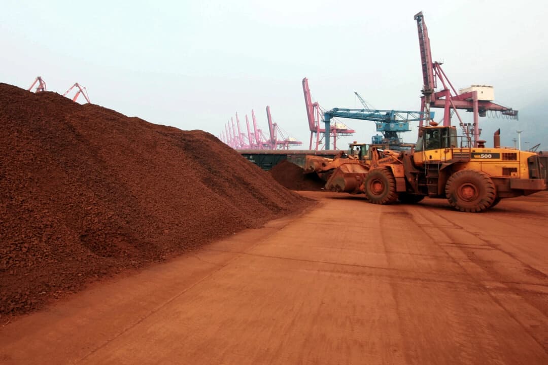 Un hombre que conduce un cargador frontal mueve tierra que contiene minerales de tierras raras para ser cargados en un puerto en Lianyungang, provincia de Jiangsu, China, el 5 de septiembre de 2010. (STR/AFP vía Getty Images)
