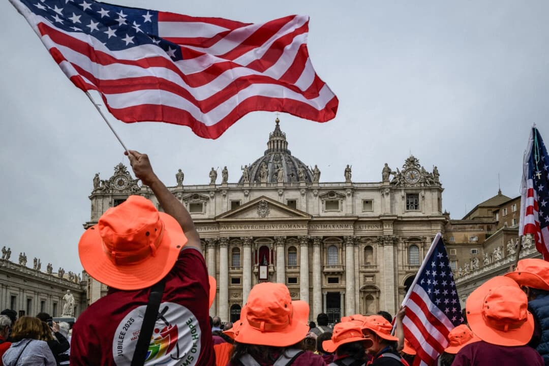 Personas con banderas estadounidenses en la Plaza de San Pedro, con la Basílica de San Pedro al fondo, en el Vaticano, el 11 de mayo de 2025. (Jeff Pachoud/AFP vía Getty Images)