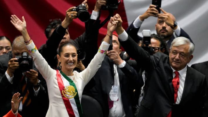 La nueva presidenta de México, Claudia Sheinbaum (izq.), y el presidente saliente, Andrés Manuel López Obrador, saludan a los asistentes durante la ceremonia de toma de posesión en el Congreso de la Unión, en la Ciudad de México, el 1 de octubre de 2024. (Foto: Alfredo ESTRELLA/AFP)