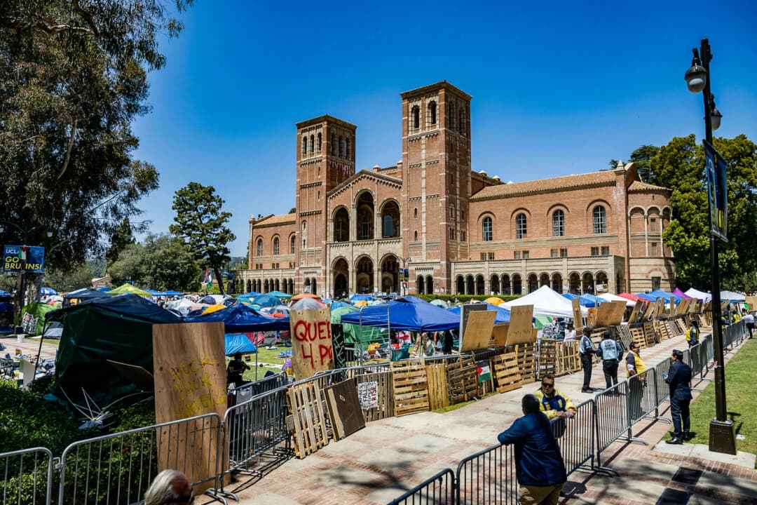 Manifestantes pro palestinos reconstruyen la barricada que rodea su campamento tras los enfrentamientos que estallaron durante la noche del 1 de mayo de 2024 en el campus de la Universidad de California-Los Ángeles (UCLA). (Etienne Laurent/AFP a través de Getty Images).