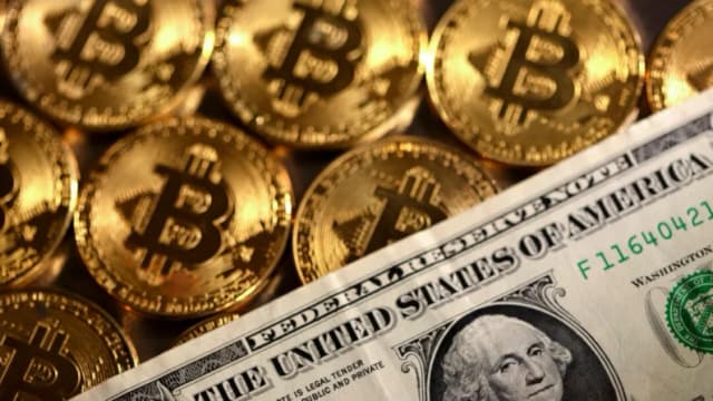 Representaciones de la criptomoneda bitcoin y el dólar estadounidense, en esta ilustración del 10 de agosto de 2022. (Dado Ruvic/Reuters)