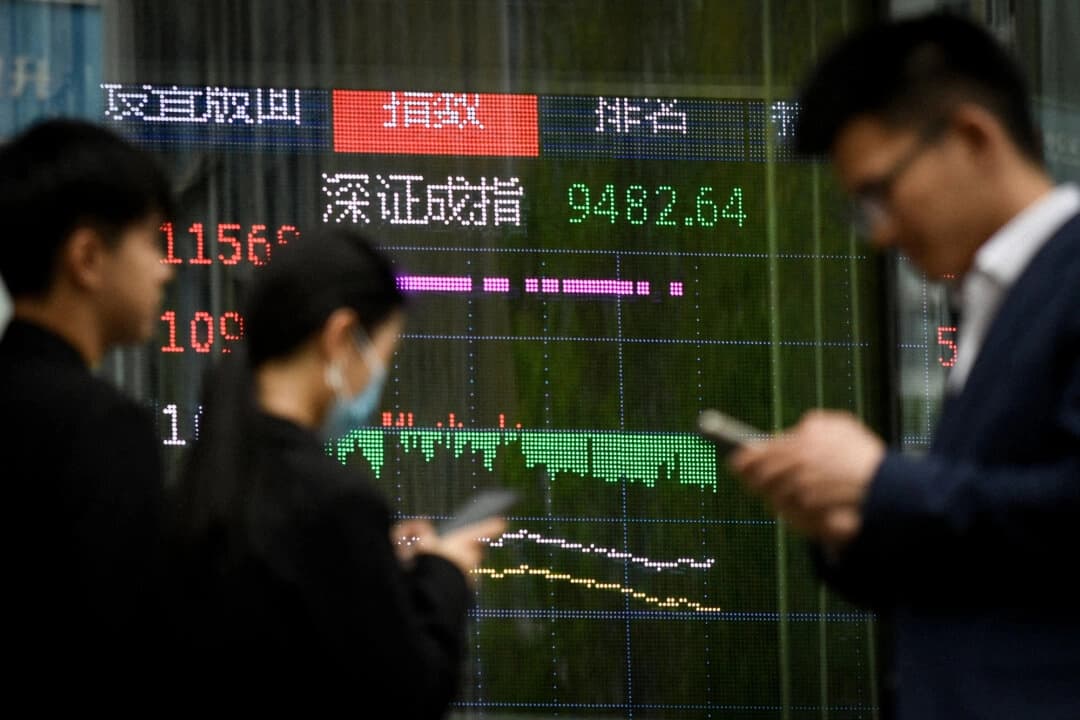 La gente pasa frente a una pantalla que muestra la evolución de la bolsa china en Beijing, el 7 de abril de 2025. (Wang Zhao/AFP vía Getty Images)