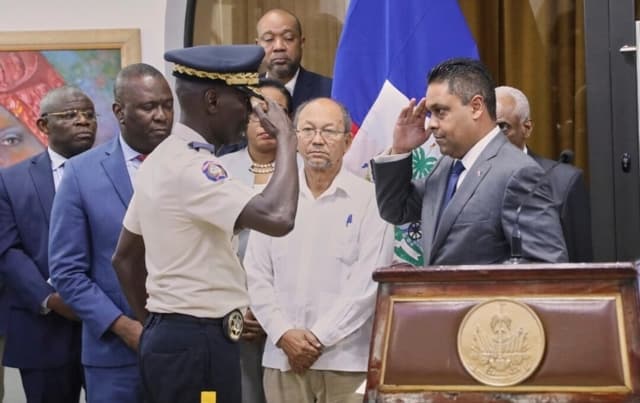 El recién nombrado jefe de policía Vladimir Paraison (izq.) saluda al presidente del Consejo de Transición, Laurent Saint-Cyr, durante su ceremonia de presentación como nuevo jefe de policía interino en Puerto Príncipe, Haití, el 8 de agosto de 2025. (Odelyn Joseph/Foto AP)