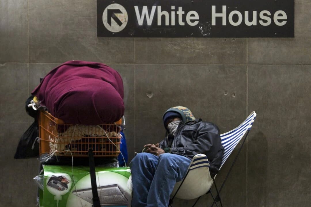 Un hombre sin hogar se acomoda para pasar la noche en una parada de metro cerca de la Casa Blanca en Washington, D.C., el 4 de diciembre de 2007. (Paul Richards/AFP vía Getty Images)