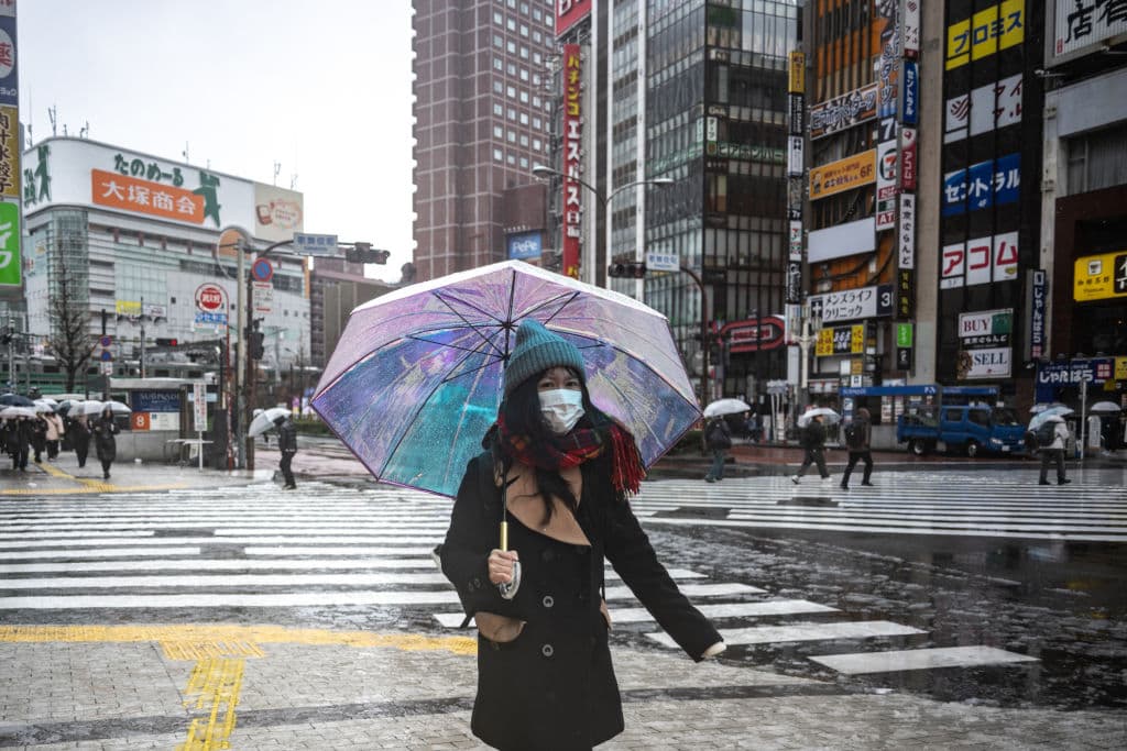 Una mujer camina con un paraguas mientras nieva y llueve en Tokio (Foto de PHILIP FONG/AFP/Getty Images)