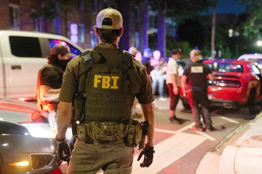 Agentes federales interrogan a una pareja que se encontraba estacionada fuera de la zona legal de estacionamiento mientras comían comida para llevar de McDonald's cerca de la calle Kennedy NW en Washington el 12 de agosto de 2025. La pareja fue liberada tras registrar el vehículo. (Foto AP/Jacquelyn Martin)
