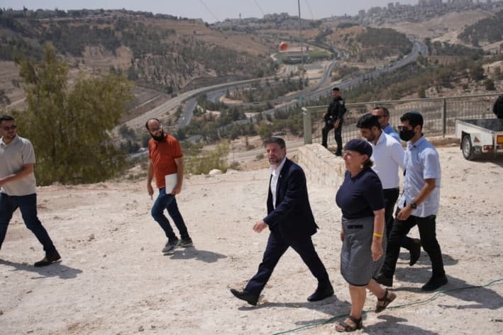 El ministro de Finanzas israelí, Bezalel Smotrich (centro), llega a una conferencia de prensa sobre la construcción de un nuevo asentamiento cerca de Maale Adumim, en Cisjordania ocupada por Israel, el 14 de agosto de 2025. (Ohad Zwigenberg/AP)