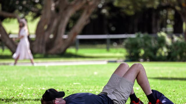 Un hombre descansa con la gorra sobre el rostro en los Royal Botanical Gardens durante el Día Mundial del Sueño, que busca concienciar sobre la importancia del sueño y el aumento de la privación y los trastornos del sueño, en Sídney el 13 de marzo de 2024. (DAVID GRAY/AFP via Getty Images)