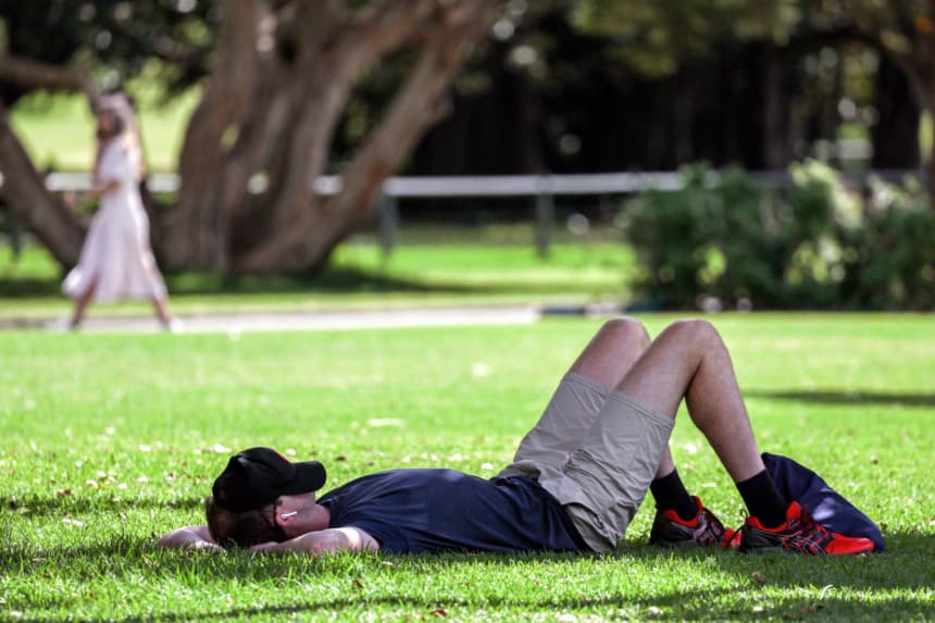 Un hombre descansa con la gorra sobre el rostro en los Royal Botanical Gardens durante el Día Mundial del Sueño, que busca concienciar sobre la importancia del sueño y el aumento de la privación y los trastornos del sueño, en Sídney el 13 de marzo de 2024. (DAVID GRAY/AFP via Getty Images)