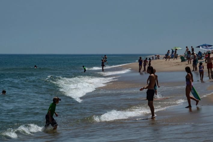 La gente nada en el agua de la playa Newcomb en Wellfleet, Massachusetts, el 21 de julio de 2024. (Joseph Prezioso/AFP vía Getty Images)