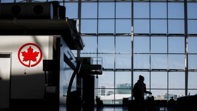 Viajero empuja su equipaje cerca del logotipo en el Aeropuerto Internacional Pearson de Toronto, el 1 de abril de 2020, en Toronto, Canadá. (Foto de Cole Burston/Getty Images)