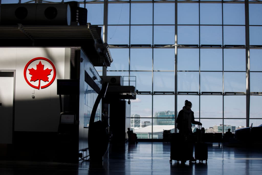 Viajero empuja su equipaje cerca del logotipo en el Aeropuerto Internacional Pearson de Toronto, el 1 de abril de 2020, en Toronto, Canadá. (Foto de Cole Burston/Getty Images)
