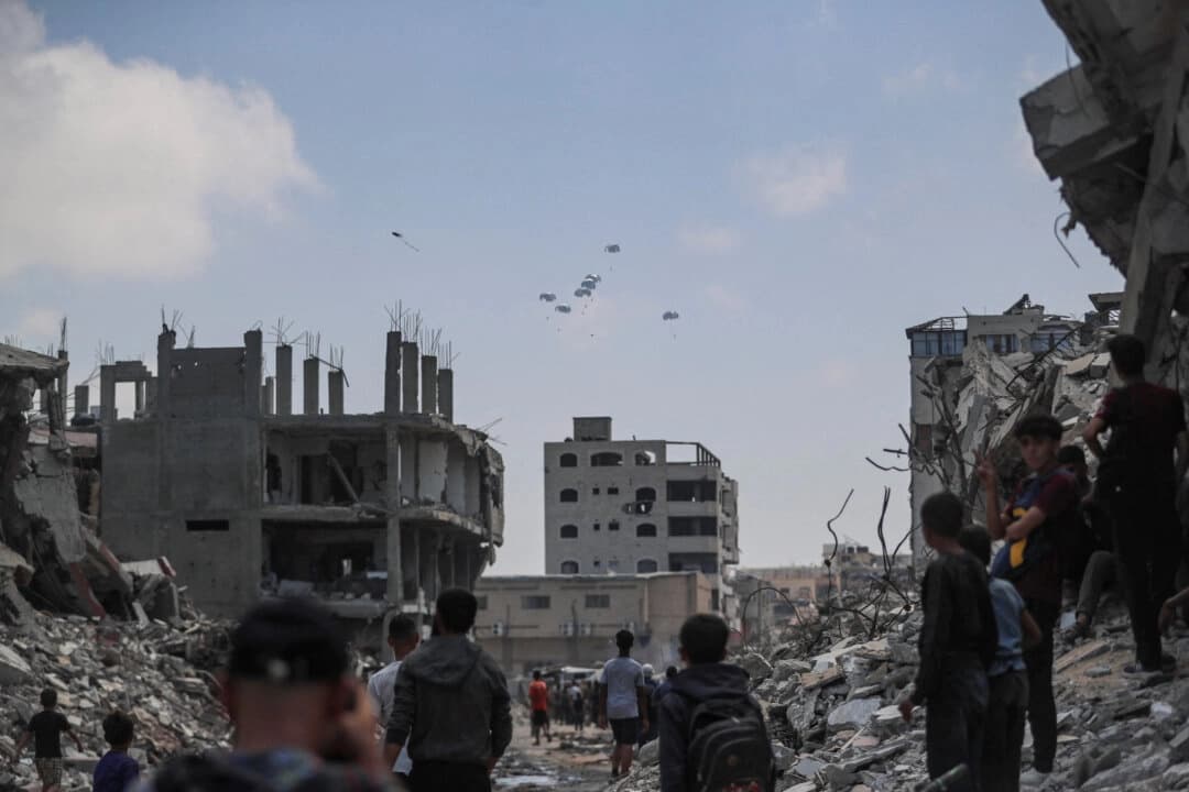 Palestinos observan paquetes de ayuda lanzados desde el aire sobre Gaza, en la ciudad de Gaza, el 8 de agosto de 2025. (Mahmoud Issa/Reuters)