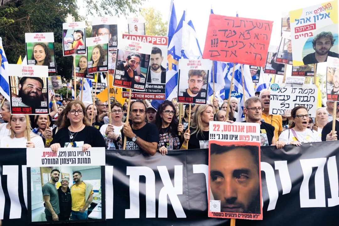Familiares de los rehenes y simpatizantes sostienen fotos de los rehenes durante una manifestación en la que se pide un acuerdo para su liberación en Tel Aviv, Israel, el 17 de agosto de 2025. (Amir Levy/Getty Images)
