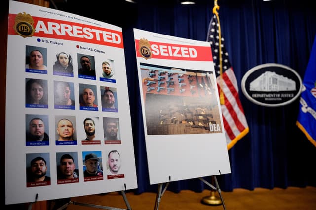 Carteles con imágenes de personas detenidas y armas de fuego incautadas se exhiben en el Departamento de Justicia el 6 de mayo de 2025 en Washington, D.C. (Andrew Harnik/Getty Images)