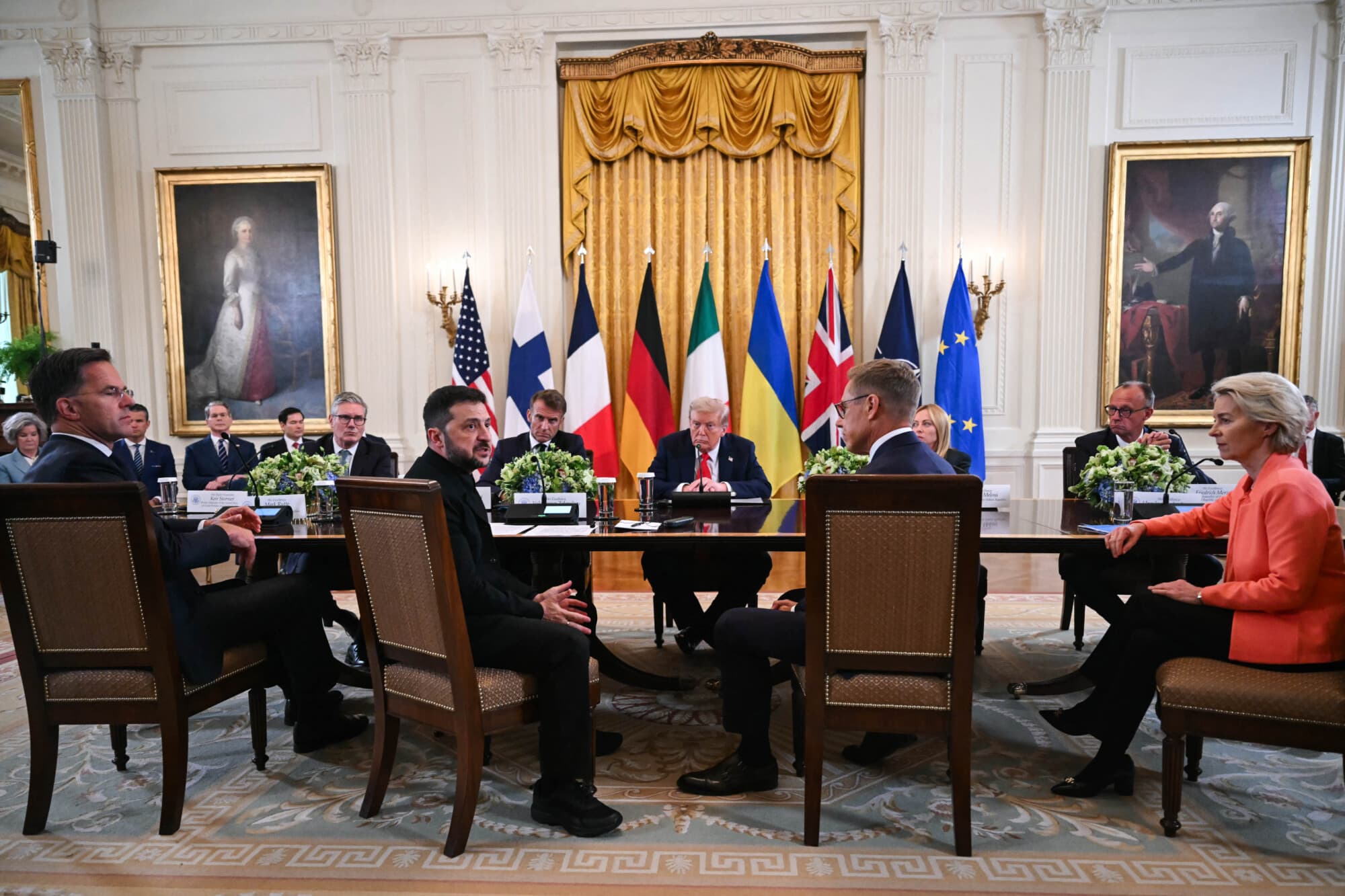 (De izq. a der.) El secretario general de la OTAN, Mark Rutte; el primer ministro británico, Keir Starmer; el presidente ucraniano, Volodymyr Zelensky; el presidente francés, Emmanuel Macron; el presidente estadounidense, Donald Trump; el presidente finlandés, Alexander Stubb; la primera ministra italiana, Giorgia Meloni; el canciller alemán, Friedrich Merz; y la presidenta de la Comisión Europea, Ursula von der Leyen, participan en una reunión en la Sala Este de la Casa Blanca el 18 de agosto de 2025. Andrew Caballero-(Reynolds/AFP vía Getty Images)

