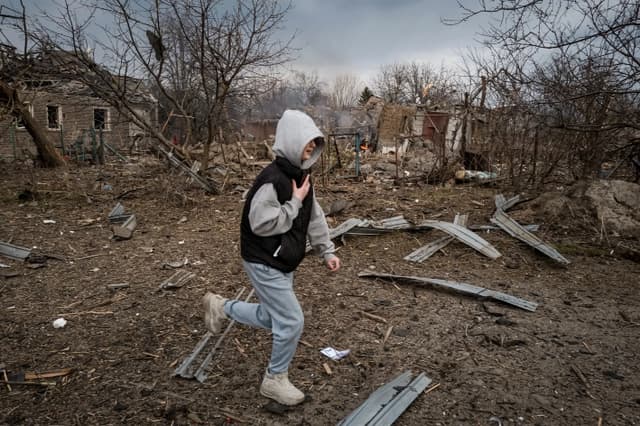 Un adolescente corre junto a una casa en llamas destruida por los bombardeos rusos en una zona residencial civil de la ciudad de Kramatorsk, Ucrania, el 22 de marzo de 2025. (Philippe de Poulpiquet/Hans Lucas/AFP a través de Getty Images)
