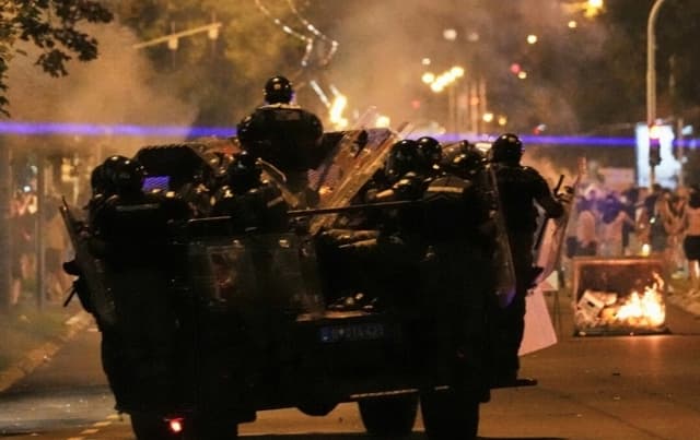 Agentes de la gendarmería serbia persiguen a manifestantes durante una protesta antigubernamental en Belgrado, Serbia, el 18 de agosto de 2025. (Darko Vojinovic/AP)