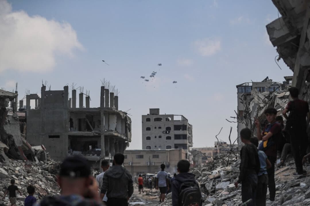 Palestinos observan los paquetes de ayuda lanzados desde el aire sobre Gaza, en la ciudad de Gaza, el 8 de agosto de 2025. (Mahmoud Issa/Reuters)
