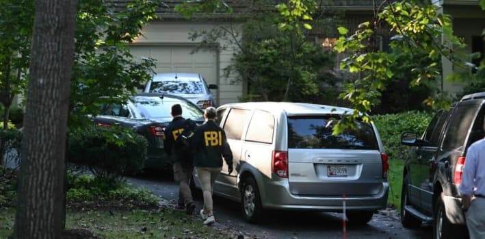 Agentes del FBI caminan afuera de la casa de John Bolton, exasesor de seguridad nacional de Donald Trump, luego de que el FBI realizó un registro judicial en su residencia en Bethesda, Maryland, el 22 de agosto de 2025. (Pedro Ugarte/AFP vía Getty Images)