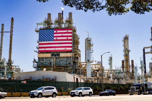 Una refinería de petróleo exhibe una bandera estadounidense en Wilmington, California, el 21 de septiembre de 2022. (Allison Dinner/Getty Images)