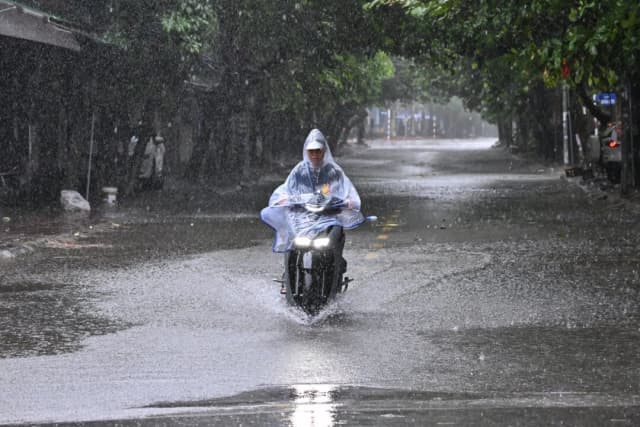 Un motociclista atraviesa una calle parcialmente inundada durante las fuertes lluvias en la ciudad de Vinh, provincia de Nghe An, el 25 de agosto de 2025, donde se espera que toque tierra el tifón Kajiki. (Nhac Nguyen/AFP a través de Getty Images)