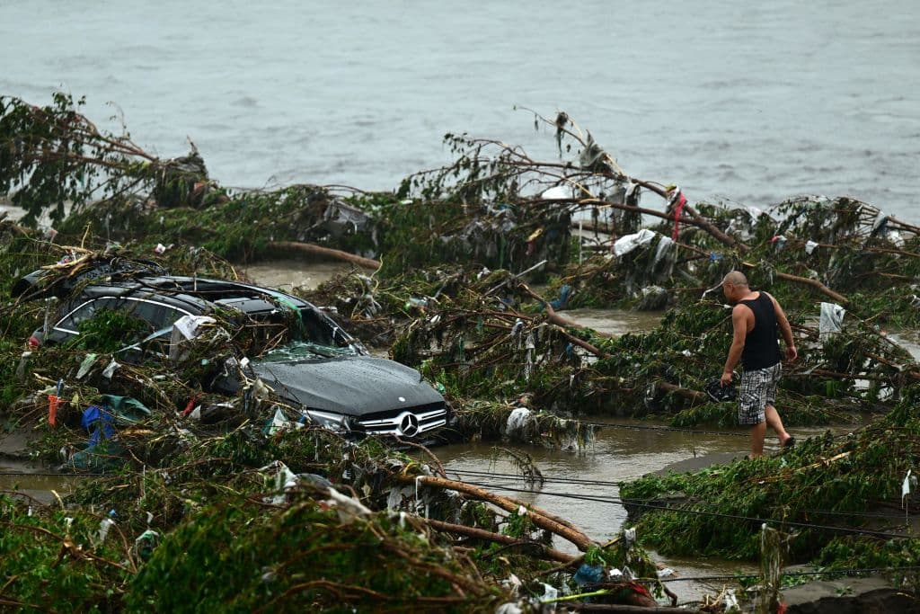 Un hombre observa un coche dañado tras las fuertes lluvias caídas en el distrito de Fangshan, en Beijing, (PEDRO PARDO/AFP a través de Getty Images)