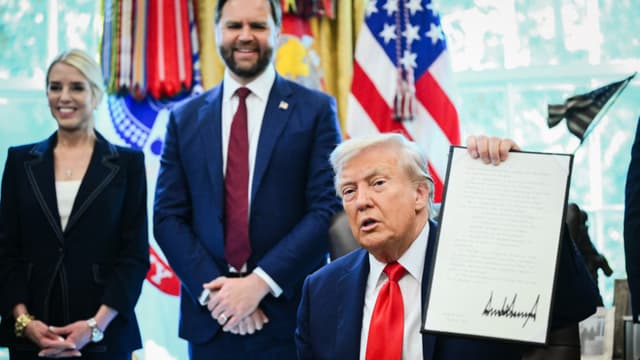 El presidente Donald Trump sostiene una orden ejecutiva firmada que tiene como objetivo poner fin a la fianza sin efectivo, en el Despacho Oval, el 25 de agosto de 2025. (Mandel Ngan/AFP a través de Getty Images).