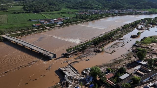 Carreteras dañadas y árboles caídos junto al desbordado río Qingshui tras las fuertes lluvias que inundaron la zona, en el distrito de Miyun, Beijing (China), el 29 de julio de 2025. (Florence Lo/Reuters)
