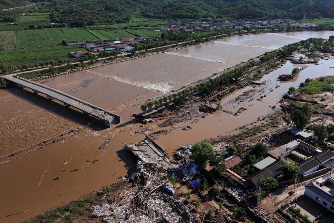 Carreteras dañadas y árboles caídos junto al desbordado río Qingshui tras las fuertes lluvias que inundaron la zona, en el distrito de Miyun, Beijing (China), el 29 de julio de 2025. (Florence Lo/Reuters)
