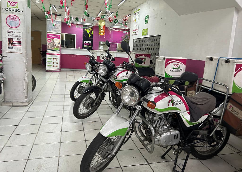 Las motocicletas postales permanecen estacionadas dentro de una oficina postal mexicana en la Ciudad de México, el 27 de agosto de 2025. El servicio postal mexicano suspendió temporalmente el miércoles las entregas de correo y paquetes a Estados Unidos tras la decisión del gobierno de Trump de imponer aranceles a todos los envíos a ese país a partir del próximo 29 de agosto. (ALFREDO ESTRELLA/AFP vía Getty Images)